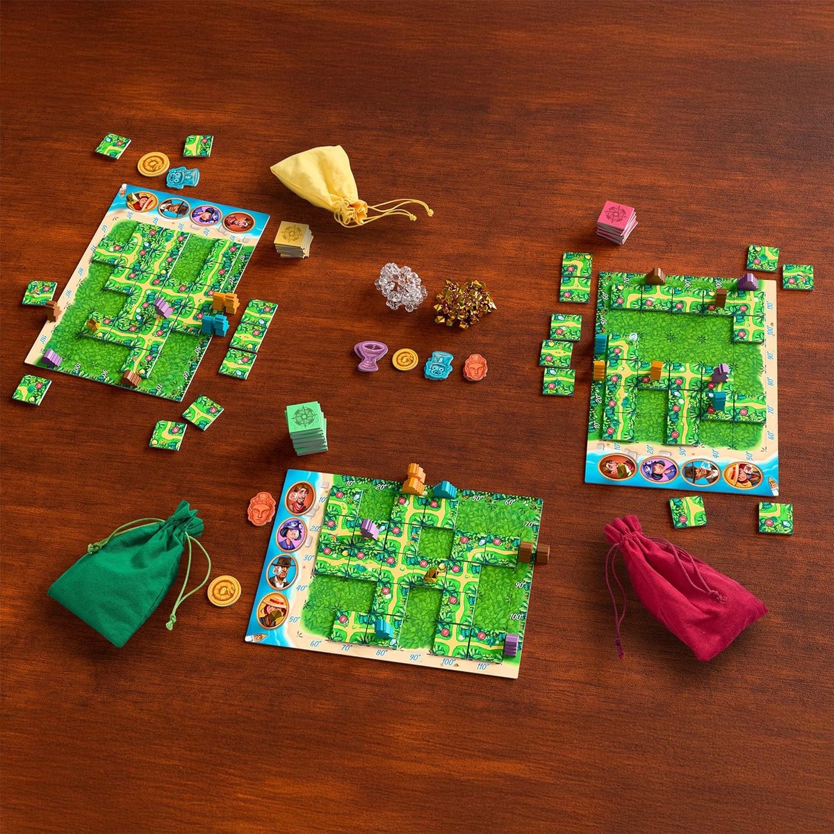 Karuba: losetas de sendero que se colocan simultáneamente, exploradores que avanzan hacia los templos y el abstracto de construcción de rutas donde todos tienen las mismas piezas pero no el mismo resultado